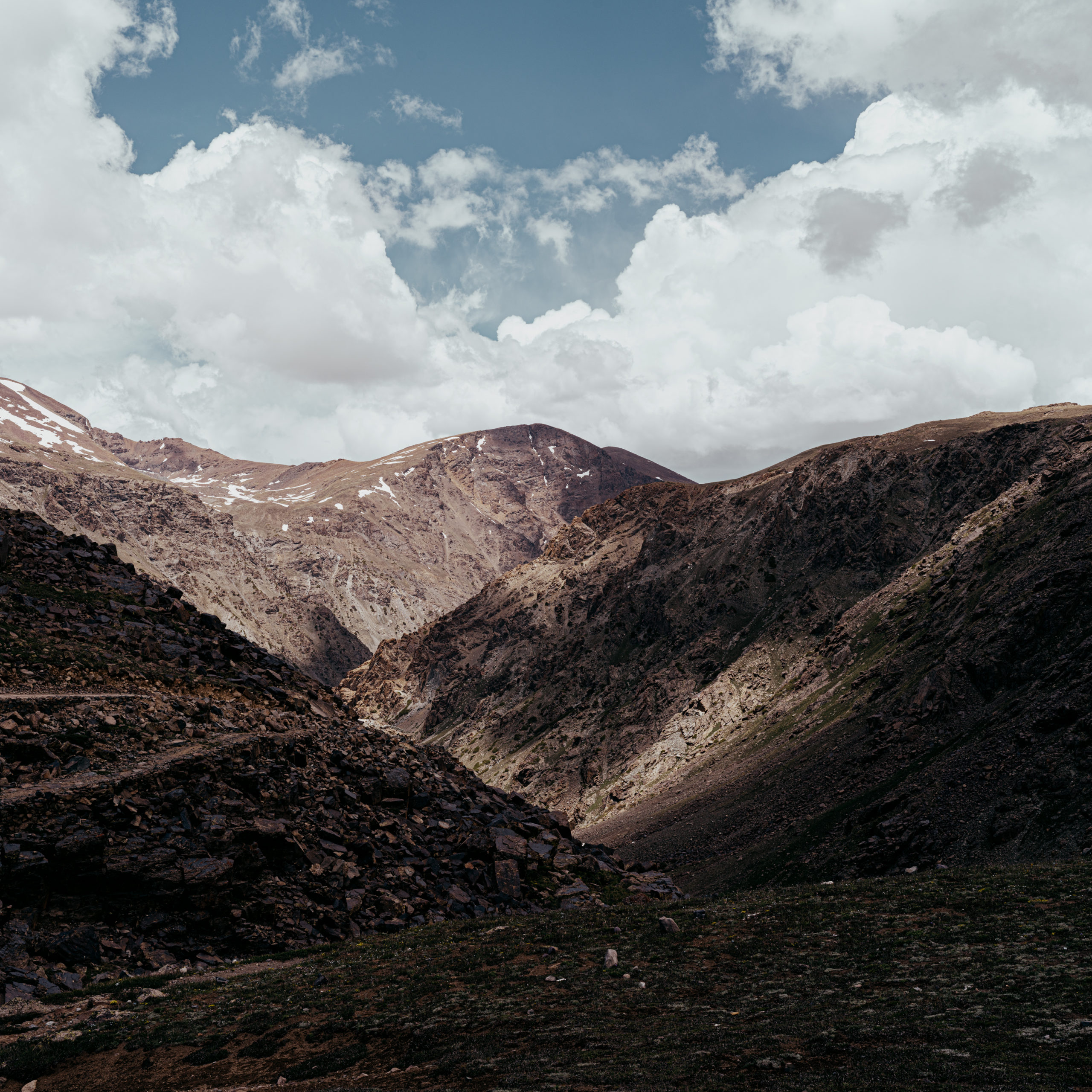 Clouds speckle a dramatic mountainous landscape