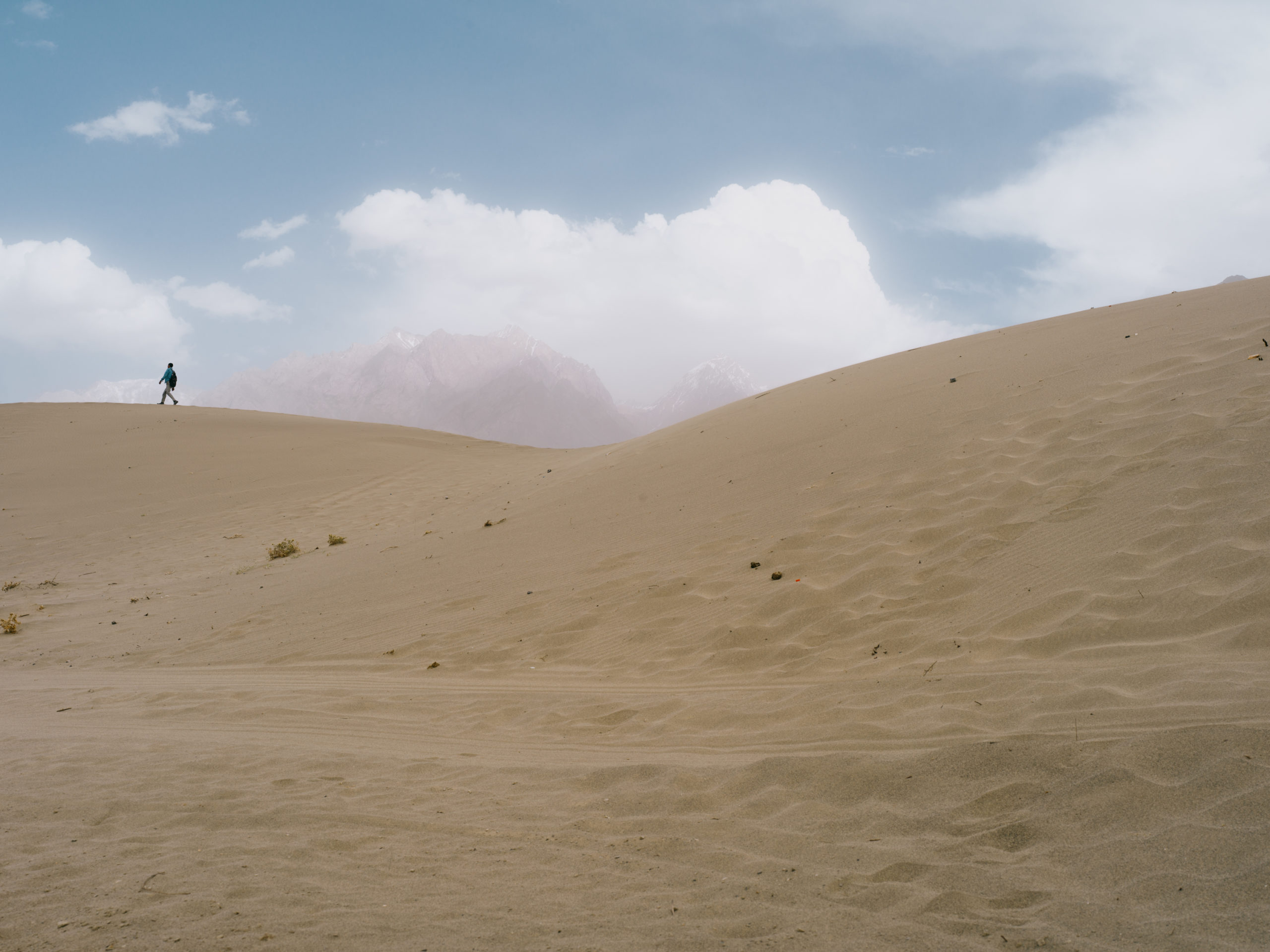 A school-boy going home across desert Sand-dunes in the Katpana desert
