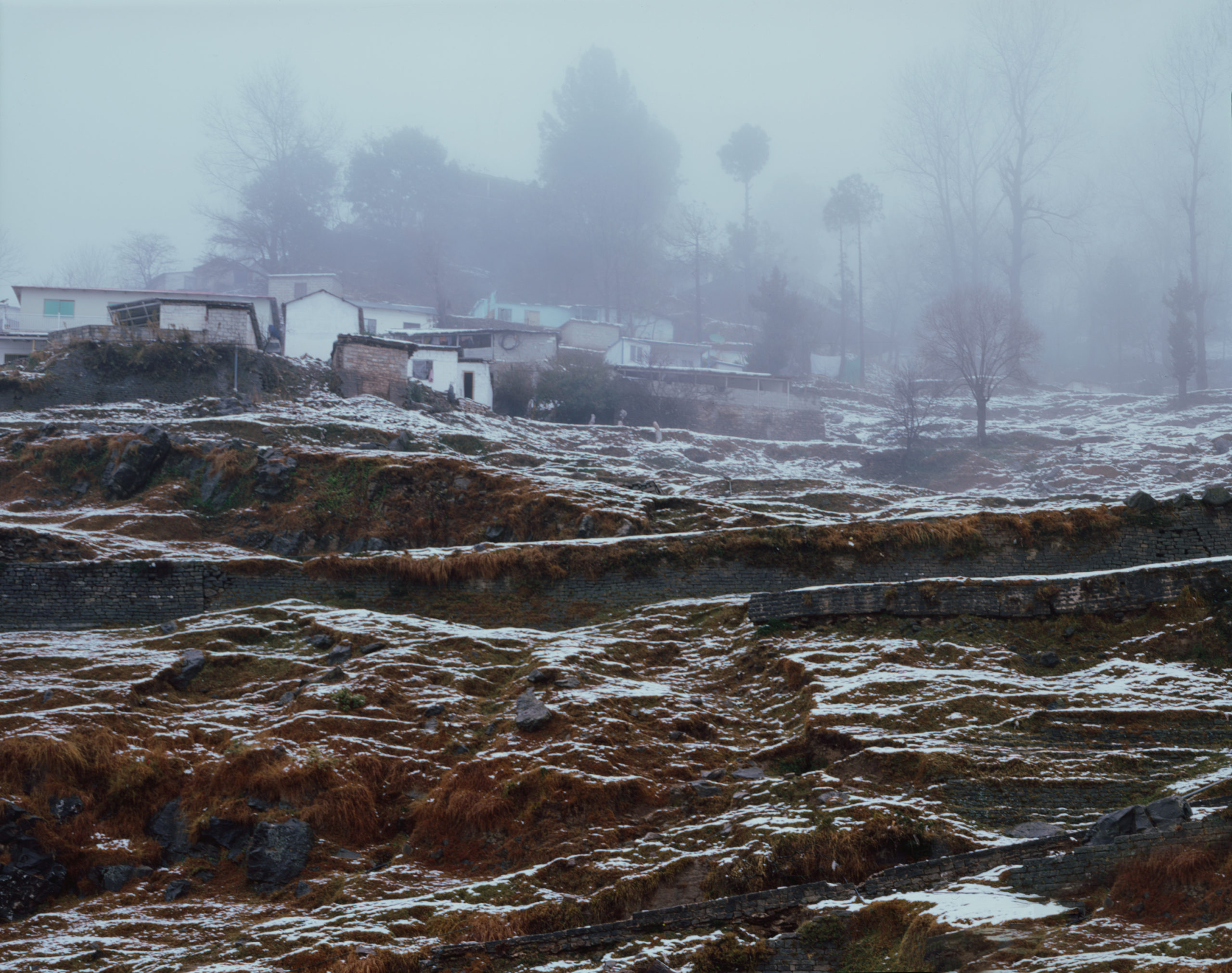 A foggy picture showing houses on a hill