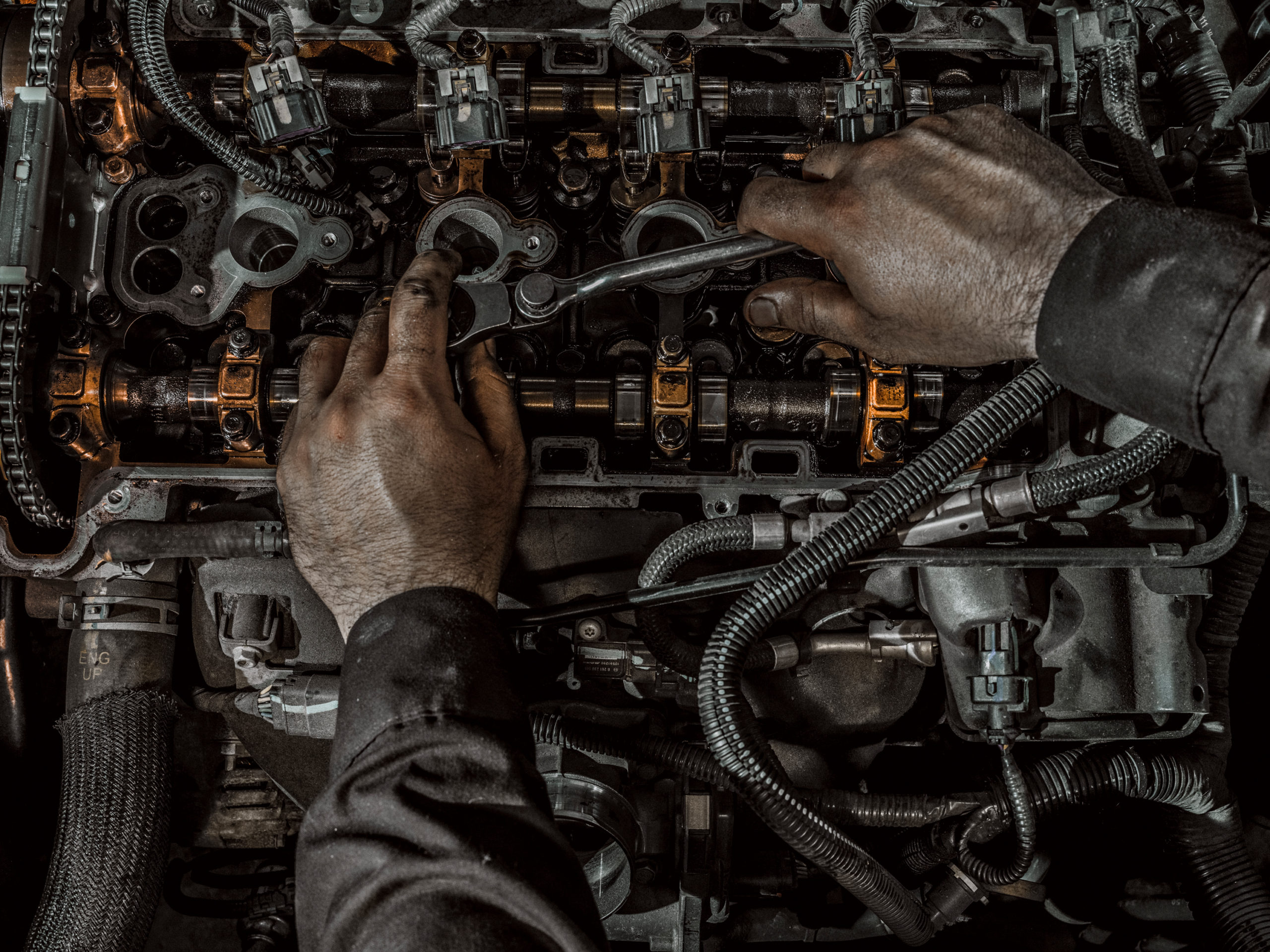 An mechanic works on a Ford engine