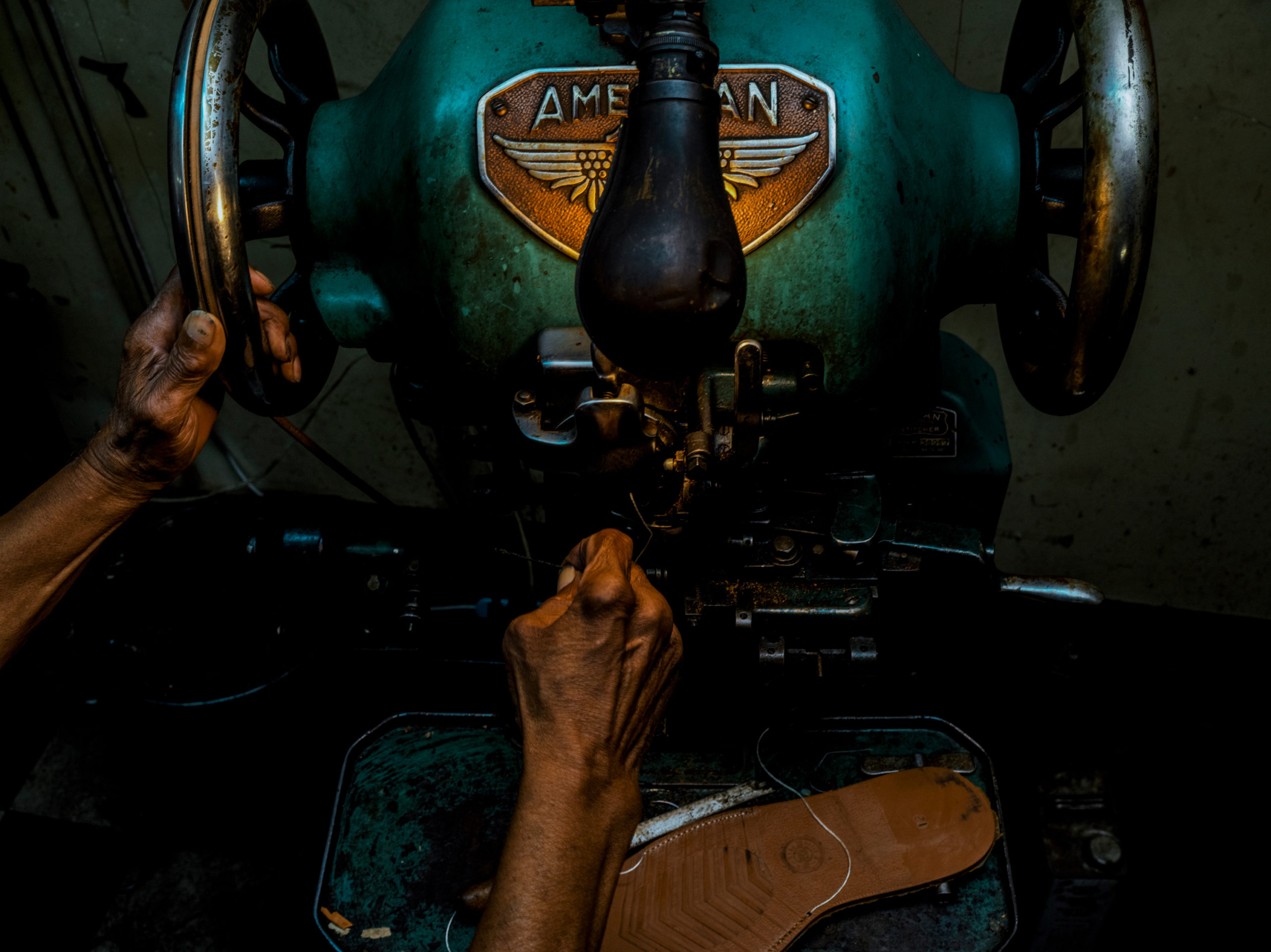 A shoemaker changes the sole of a shoe.