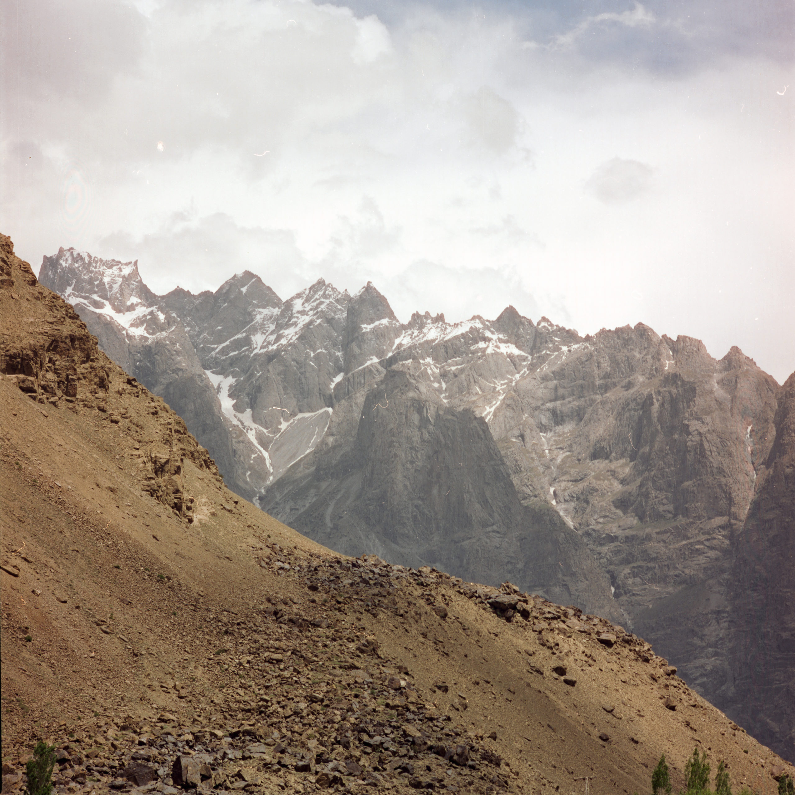 Tall Karakorum peaks photographed against the side of a mountain road 
