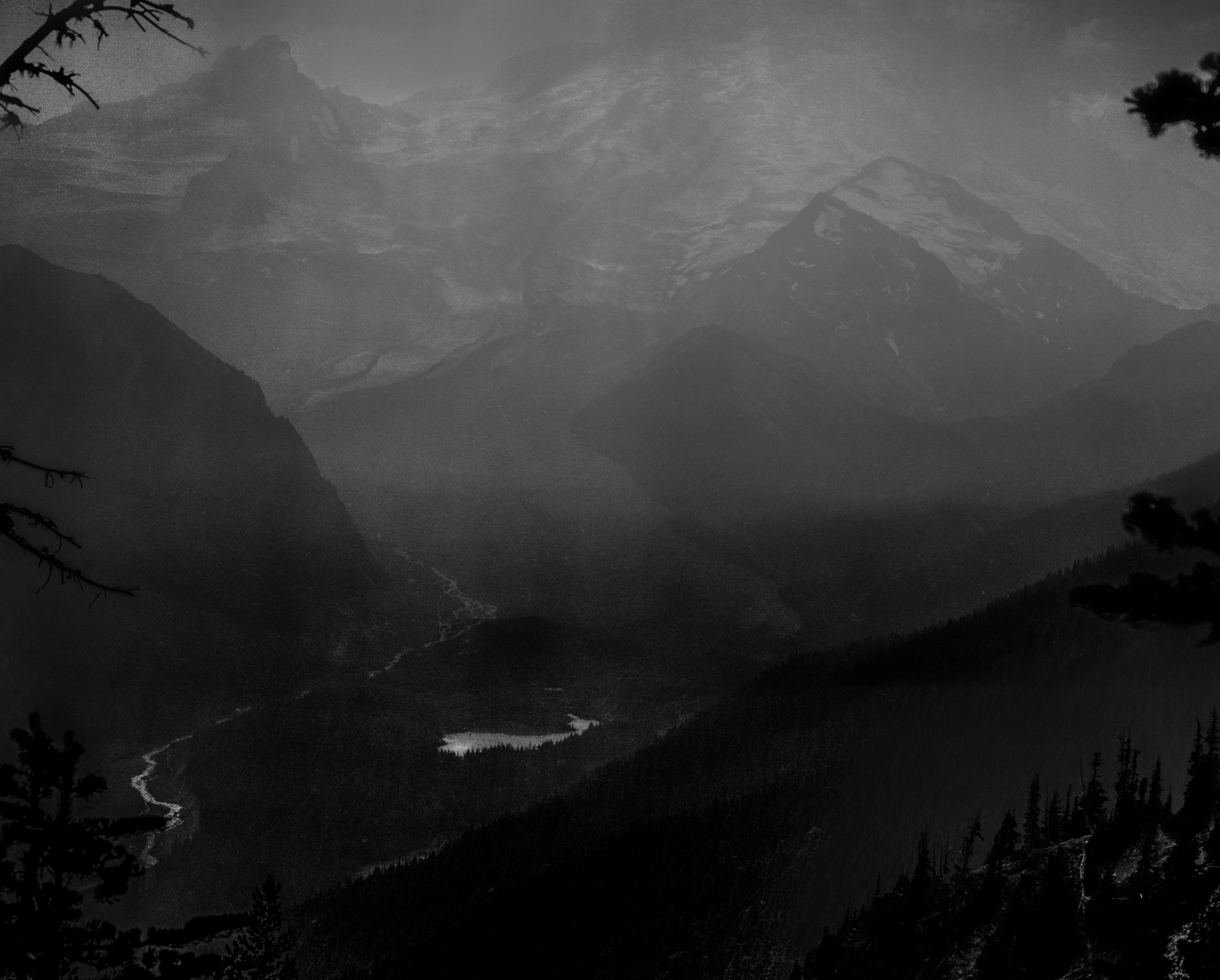 A photograph of Mount Rainier hidden between layers of smoke and soot