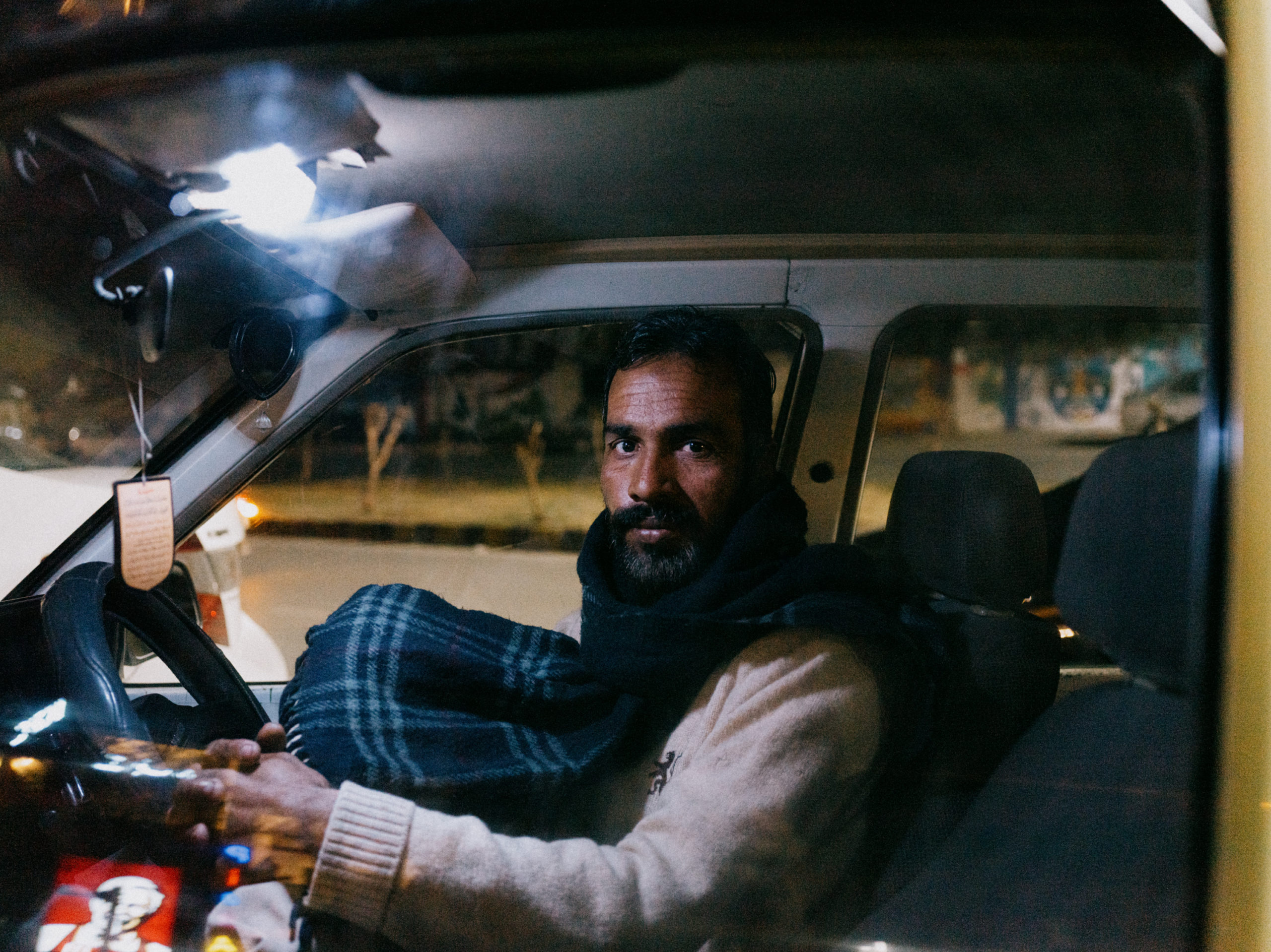 A Pakistani cab-driver waits for a ride outside KFC. 